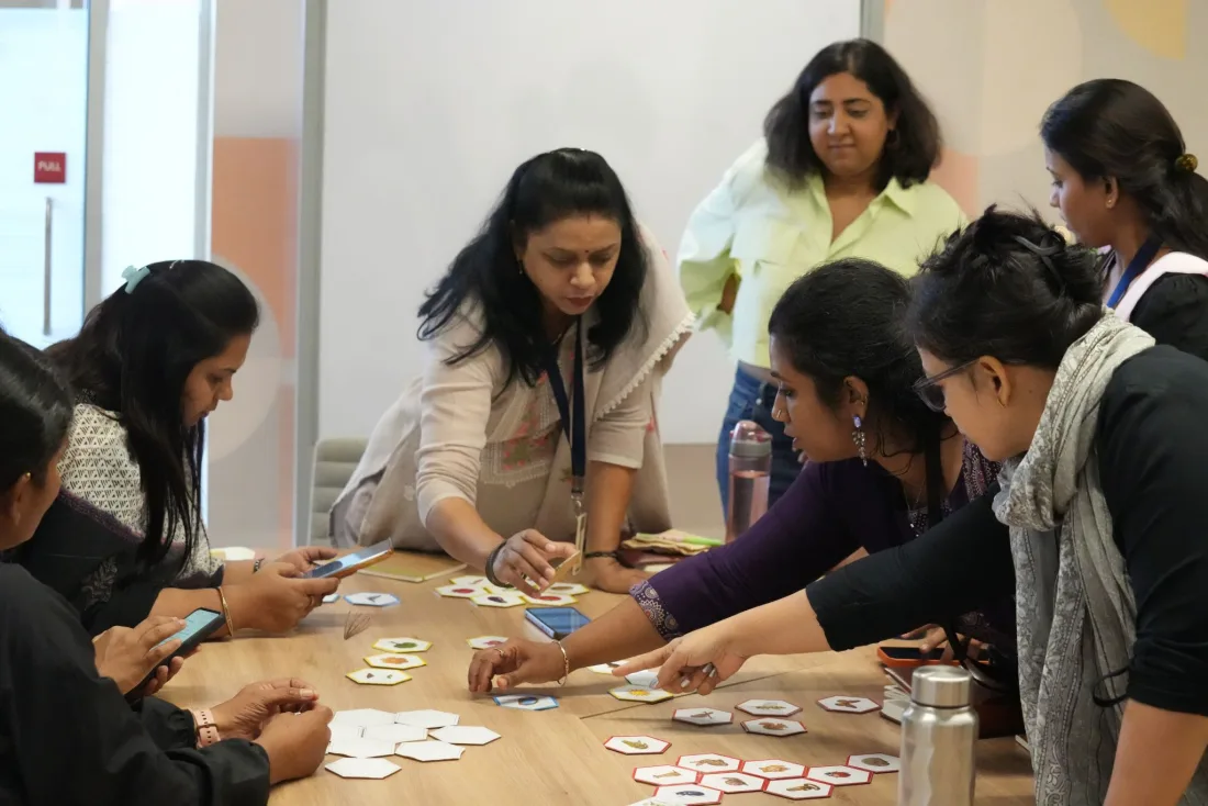 Educators gathered around a table, laying out the Growing Minds tiles together